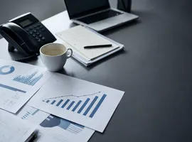 Escritorio con informes de tráfico SEO y teléfono en silencio, símbolo de agencia SEO sin generar negocio real