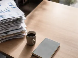 Escritorio con informes SEO y espacio vacío que simboliza el desequilibrio entre coste y resultado