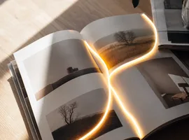 Páginas de un documento con un hilo de luz continuo, representando un CTA natural dentro de un artículo