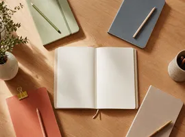 Cuadernos organizados por color representando contenido segmentado por tipo de cliente