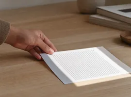 Mano revisando un documento impreso como última comprobación antes de publicar contenido