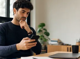 Persona revisando el móvil antes de contactar con una marca, reflejando la confianza generada en redes sociales