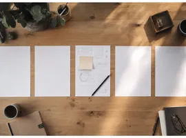 Mesa de trabajo editorial con hojas de contenido, una de ellas personalizada y diferenciada del resto