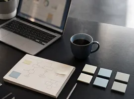 Escritorio con notas y esquemas mostrando cómo se organiza un sistema de contenido apoyado en IA