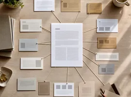 Documento central conectado a varios formatos de contenido derivados sobre una mesa, representando un motor de contenido