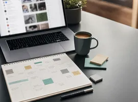 Escritorio con calendario editorial y portátil, representando un sistema de automatización de publicaciones con criterio