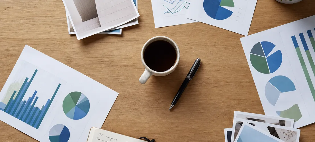 Documentos y gráficos organizados sobre una mesa representando métricas de marketing integrado