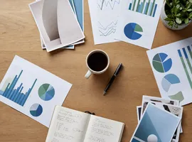 Documentos y gráficos organizados sobre una mesa representando métricas de marketing integrado