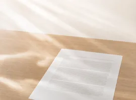 Hoja de contenido sobre un escritorio con líneas de luz que sugieren la difusión de un blog en redes sociales