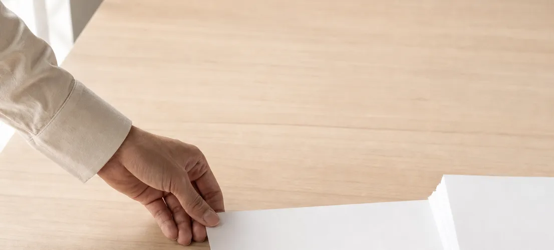 Mano impulsando una hoja de papel entre otras quietas, representando la distribución de contenido de un blog