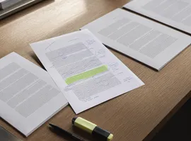 Hojas de contenido genérico junto a una página con edición manual que representa la voz de marca en IA
